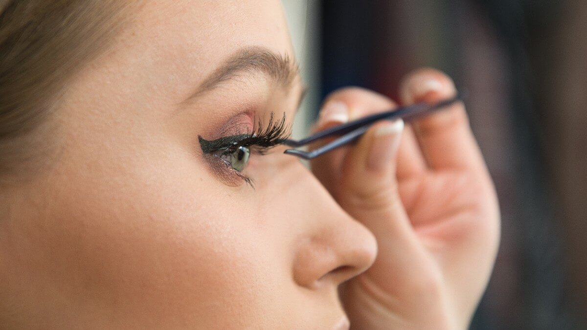 woman applying false lashes